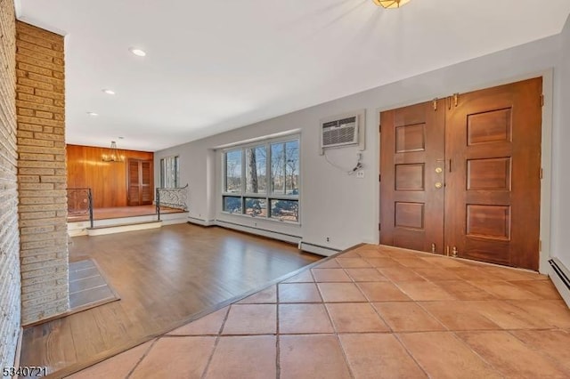 entrance foyer with wood finished floors, an inviting chandelier, baseboard heating, a wall mounted AC, and recessed lighting