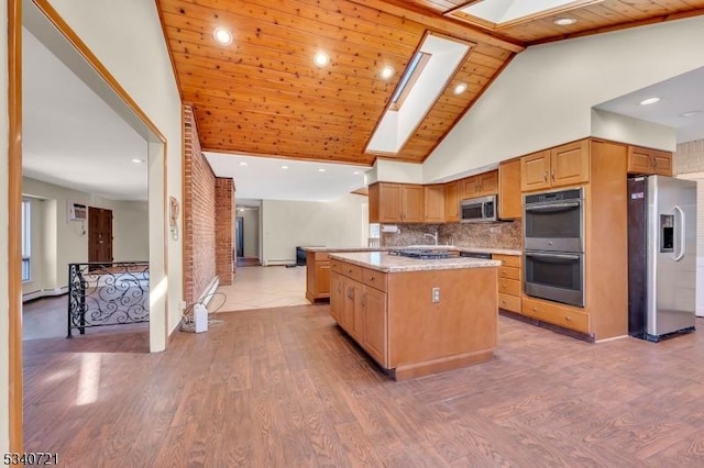 kitchen with stainless steel appliances, light wood finished floors, a skylight, and a baseboard radiator