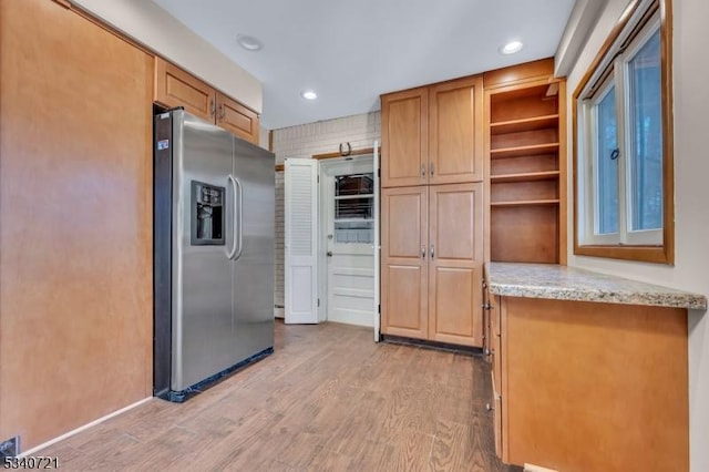 kitchen with light stone counters, open shelves, recessed lighting, light wood-style flooring, and stainless steel fridge