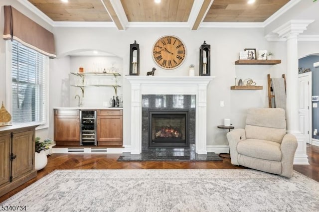 interior space with wine cooler, wooden ceiling, a high end fireplace, beam ceiling, and wet bar