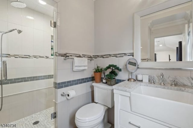 bathroom featuring vanity, a shower stall, toilet, and tile walls