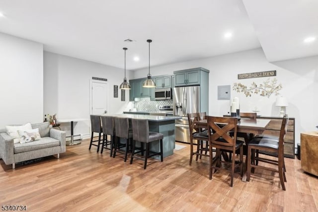 dining area featuring light wood finished floors, a baseboard radiator, visible vents, and recessed lighting