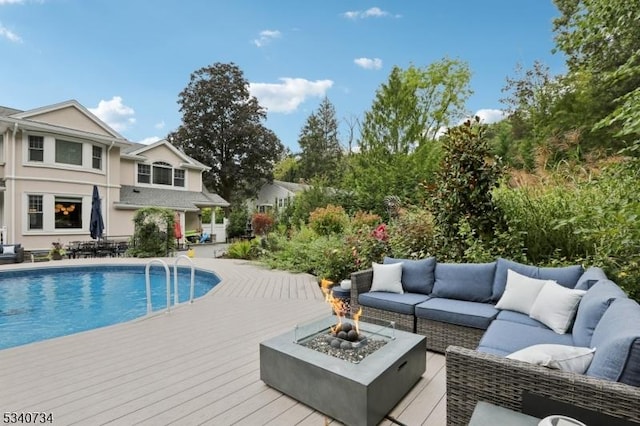 outdoor pool with an outdoor living space with a fire pit and a wooden deck