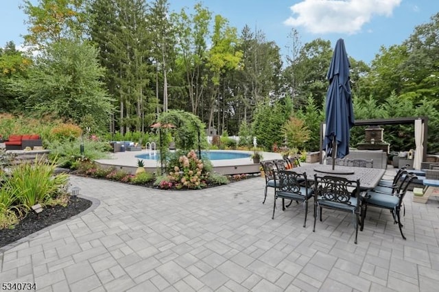 view of patio with outdoor dining area and an outdoor pool