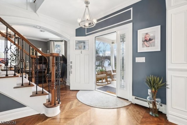 entrance foyer with ornamental molding, a notable chandelier, and stairway