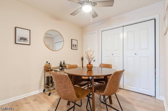 dining room with ceiling fan, light wood finished floors, and baseboards