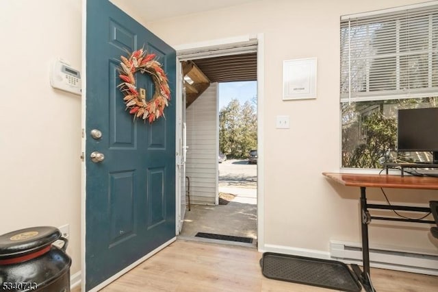 entrance foyer with a baseboard radiator, baseboards, and wood finished floors