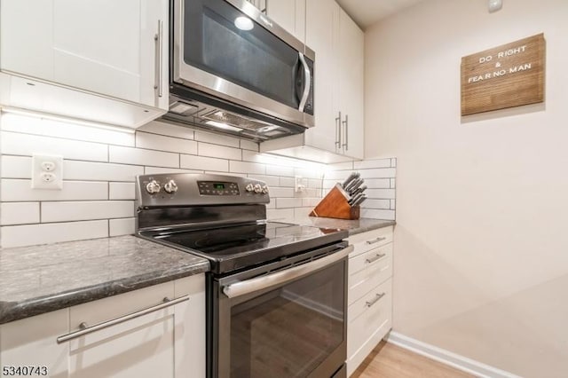 kitchen with stainless steel appliances, white cabinetry, and decorative backsplash