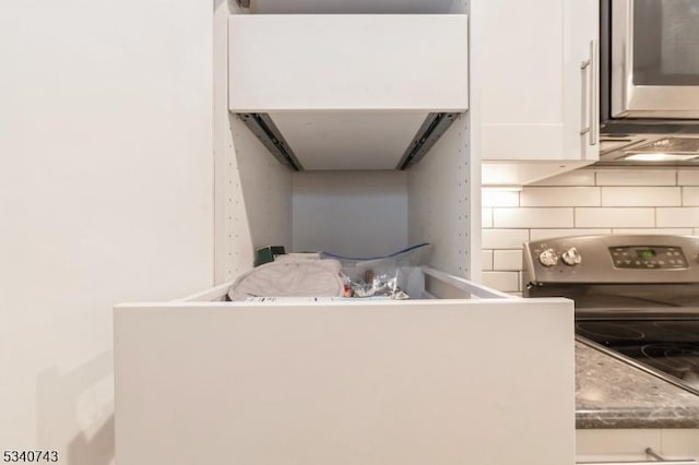 kitchen featuring appliances with stainless steel finishes, white cabinetry, and backsplash