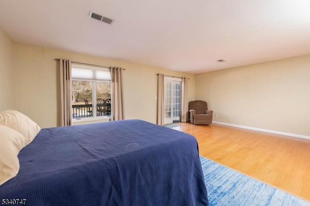 bedroom featuring wood finished floors, visible vents, and baseboards