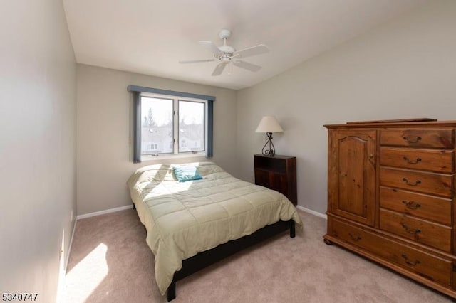 bedroom featuring light colored carpet, ceiling fan, and baseboards