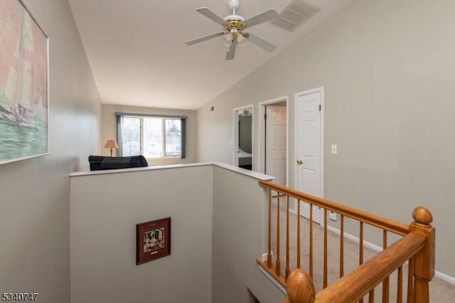 interior space with baseboards, visible vents, vaulted ceiling, and an upstairs landing