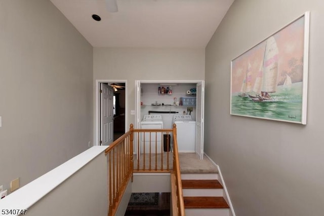 corridor with washer and dryer, baseboards, and an upstairs landing