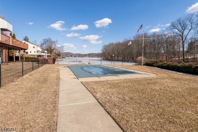 view of pool featuring a fenced in pool, a yard, a patio, a water view, and fence