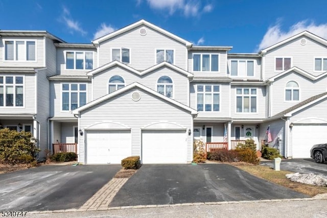 multi unit property featuring a garage and driveway