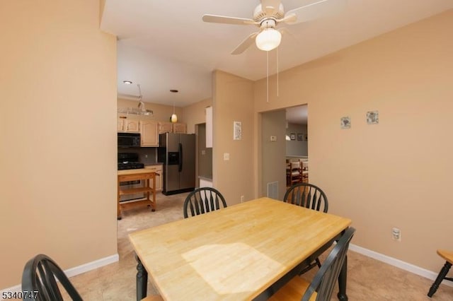 dining space with ceiling fan and baseboards