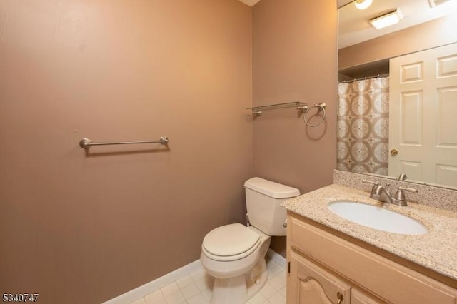 bathroom with curtained shower, toilet, vanity, baseboards, and tile patterned floors