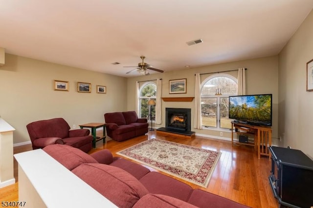 living room featuring light wood finished floors, plenty of natural light, and visible vents