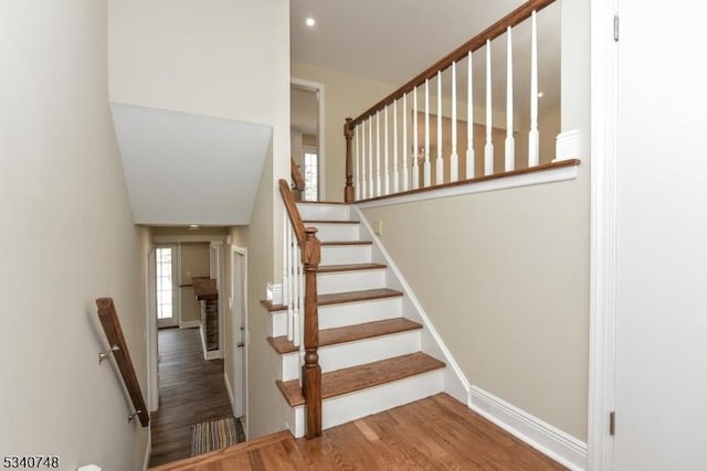 stairs with wood finished floors and baseboards