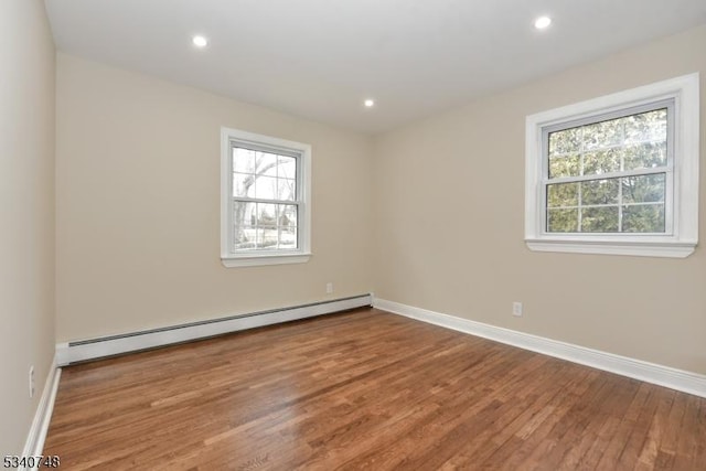 unfurnished room with recessed lighting, baseboards, baseboard heating, and wood finished floors