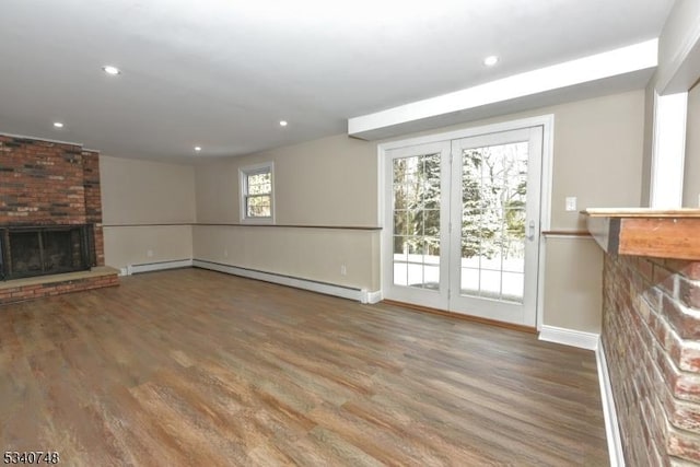 unfurnished living room with a brick fireplace, baseboards, wood finished floors, and recessed lighting