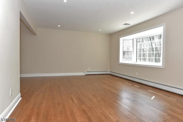 empty room with baseboards, wood finished floors, visible vents, and recessed lighting