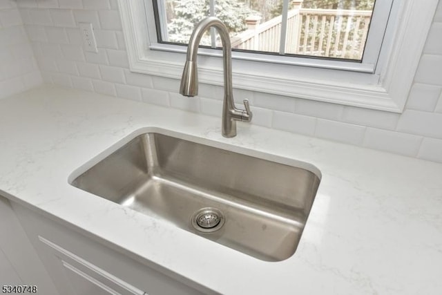 details with tasteful backsplash, light stone counters, and a sink