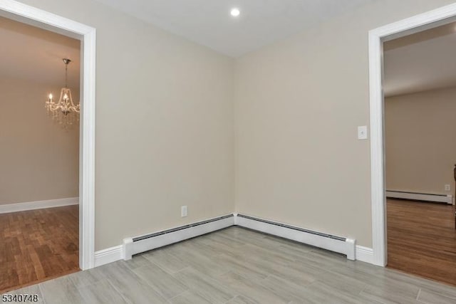 empty room featuring a baseboard radiator, light wood-style flooring, and baseboards