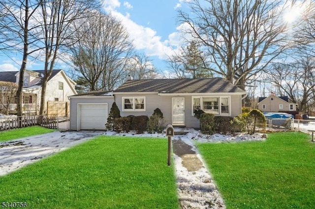 view of front of property featuring aphalt driveway, a front yard, fence, and an attached garage