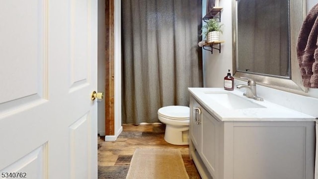 bathroom with vanity, toilet, and wood finished floors