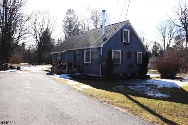 view of home's exterior featuring a yard, aphalt driveway, and roof with shingles