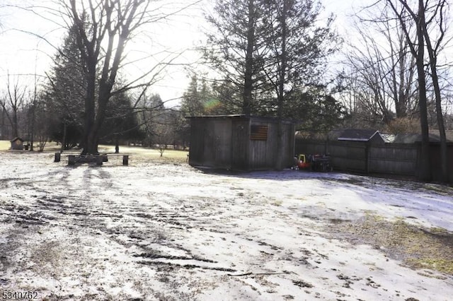 view of yard featuring a shed, an outdoor structure, and fence