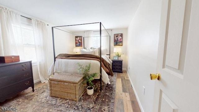 bedroom featuring baseboards and wood finished floors