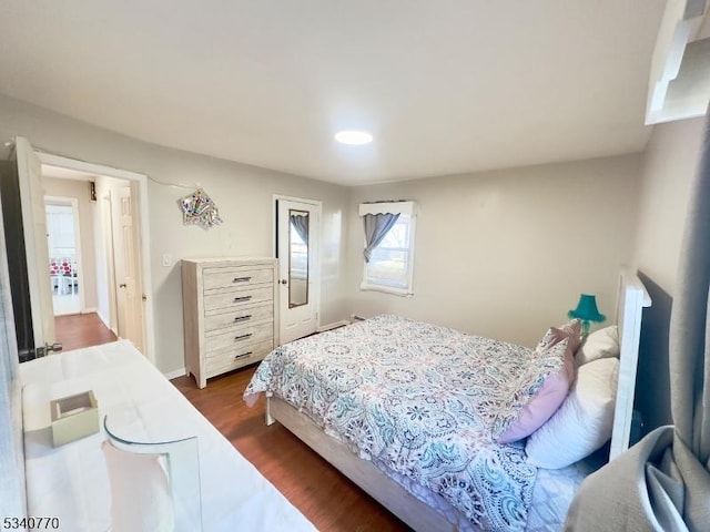 bedroom featuring dark wood-style floors and baseboards