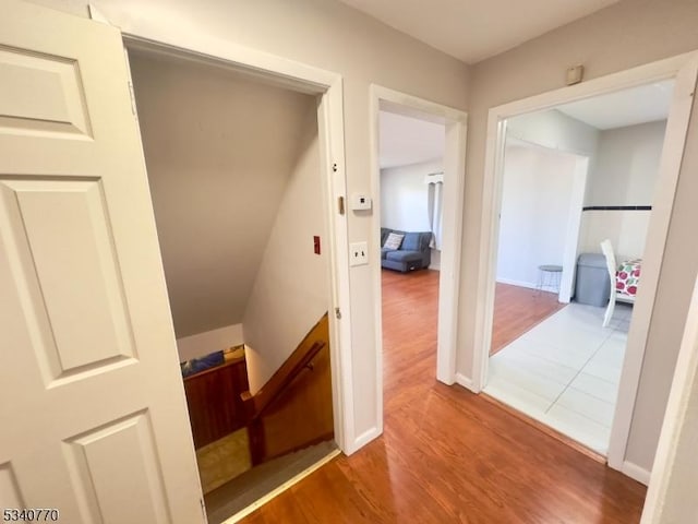 hallway with baseboards and wood finished floors