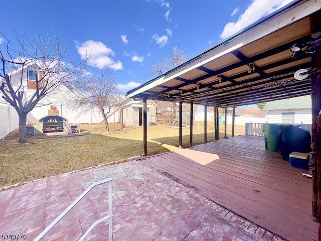 wooden terrace featuring a yard and fence