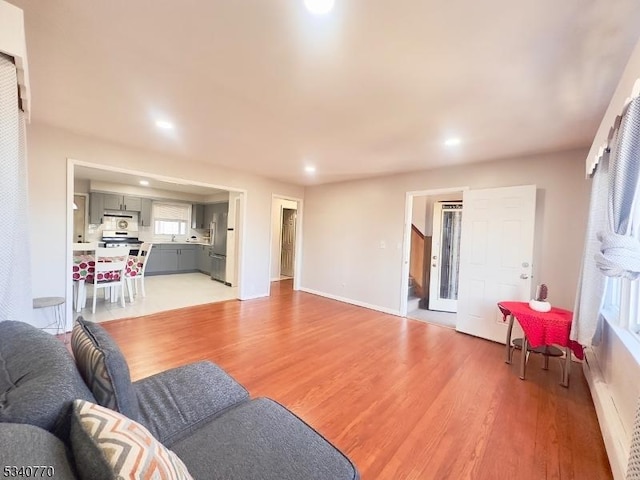 living room with light wood-type flooring, baseboards, and recessed lighting