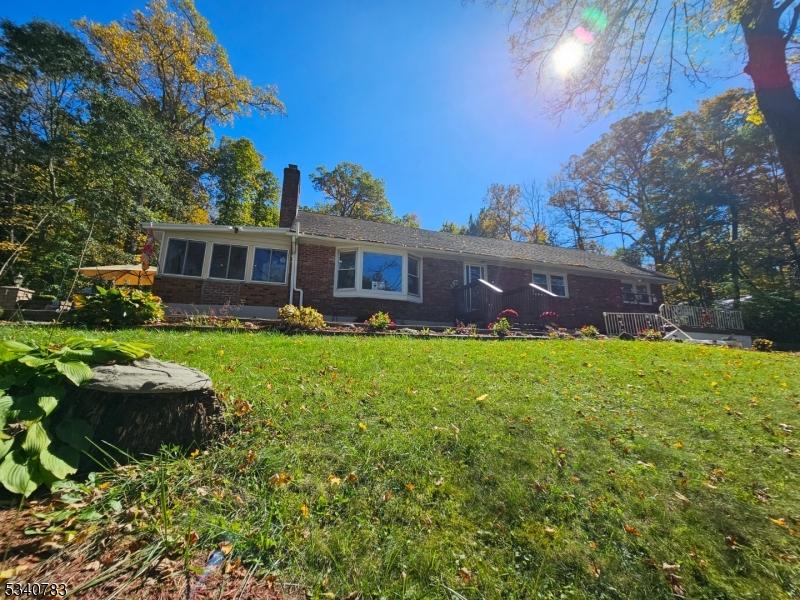ranch-style house featuring a front yard, brick siding, and a chimney