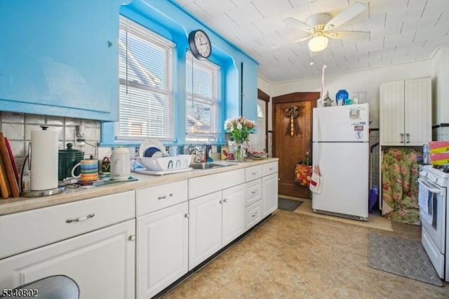 kitchen featuring a sink, white cabinetry, white appliances, light countertops, and ceiling fan