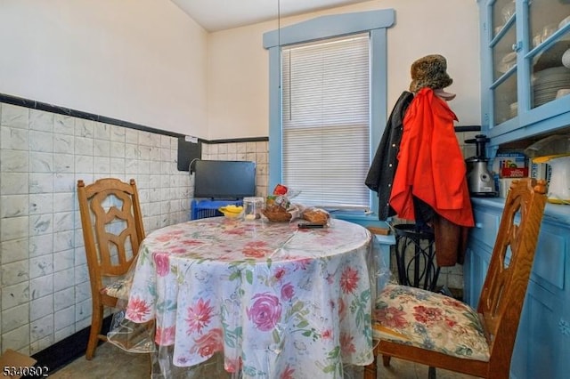 dining area with tile walls and wainscoting