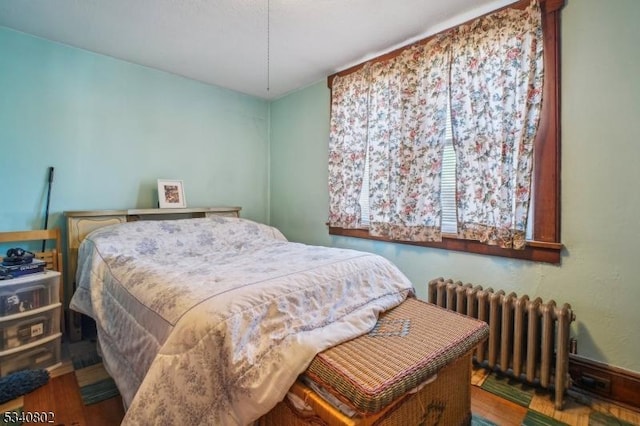 bedroom with wood finished floors and radiator heating unit