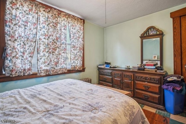 bedroom with wood finished floors and a textured ceiling