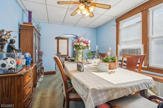 carpeted dining room with a paneled ceiling and ceiling fan