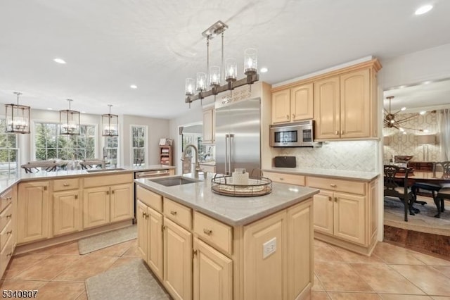 kitchen featuring light tile patterned flooring, light brown cabinets, stainless steel appliances, a sink, and tasteful backsplash