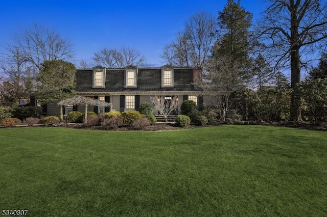 view of front of property featuring mansard roof, a front lawn, and roof with shingles