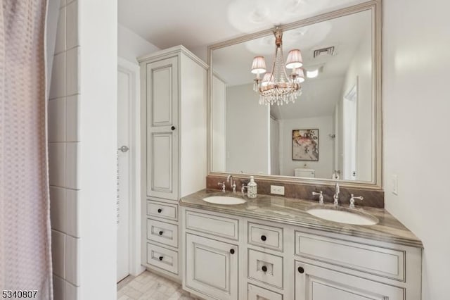 full bathroom featuring visible vents, a sink, an inviting chandelier, and double vanity