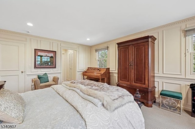 carpeted bedroom with recessed lighting and a decorative wall