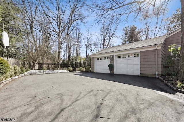 detached garage featuring fence