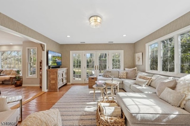 living room featuring recessed lighting, french doors, light wood-style flooring, and baseboards