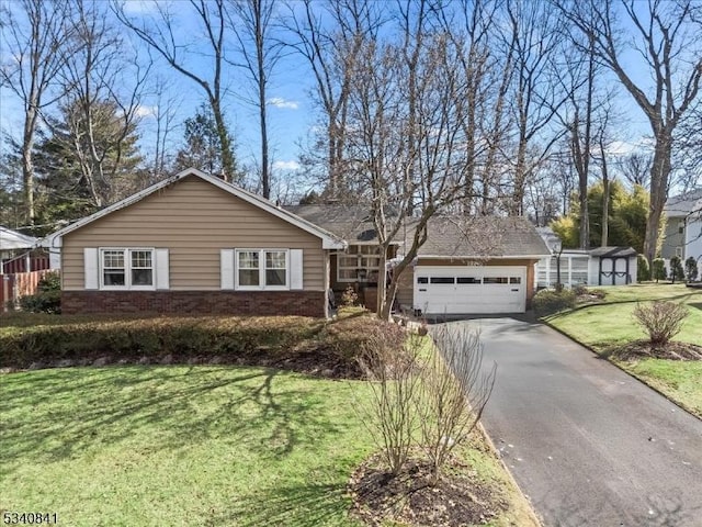 ranch-style home featuring aphalt driveway, a front yard, brick siding, and an attached garage